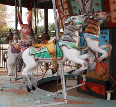 A person riding a horse in a carousel

Description automatically generated