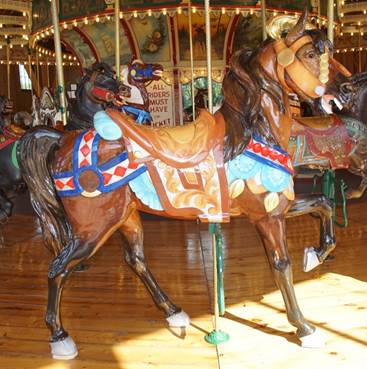 A person riding a horse in a carousel

Description generated with very high confidence