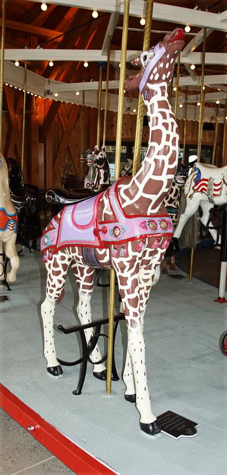 A giraffe carousel in a room

Description automatically generated