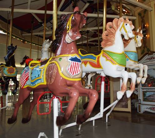 A person riding on the back of a carousel

Description automatically generated