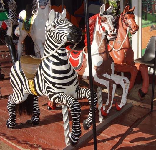 A group of zebra standing next to a statue

Description automatically generated