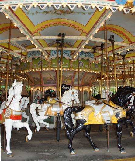 A carousel in front of a building

Description generated with very high confidence