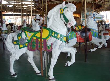 A horse statue in front of a carousel

Description generated with very high confidence