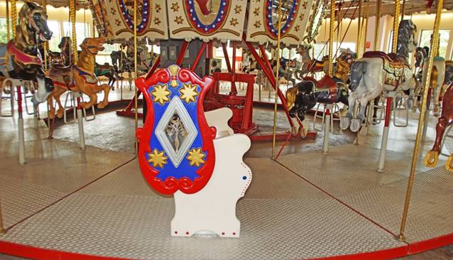 A carousel with a red and blue chair

Description automatically generated