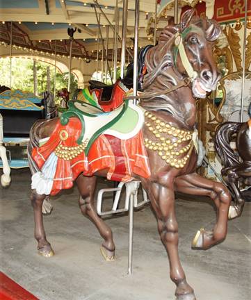 A picture containing carousel, ride, sitting, laying

Description automatically generated