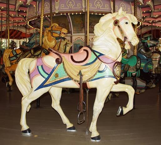 A group of people standing next to a carousel horse

Description automatically generated