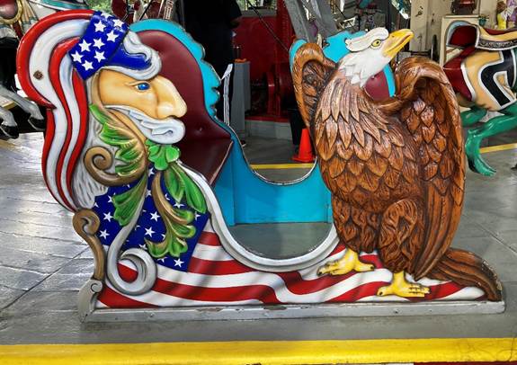 A colorful carousel with an eagle and a flag painted on it
AI-generated content may be incorrect.