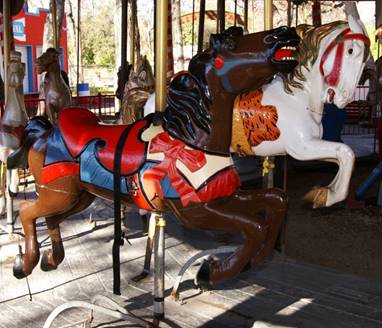 A large red chair in front of a carousel

Description generated with high confidence