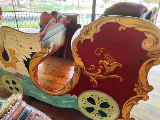 A painted wooden carriage with a horse drawn carriage

AI-generated content may be incorrect.
