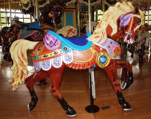 A person riding a horse in a carousel

Description automatically generated